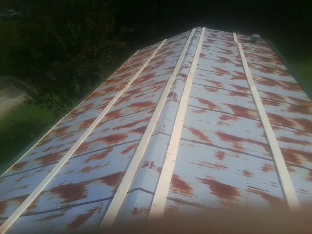 Rusted metal roof panels with new wood purlins before replacement — Storm Damage Roof Repair in Harbor Springs by Roofing Brothers