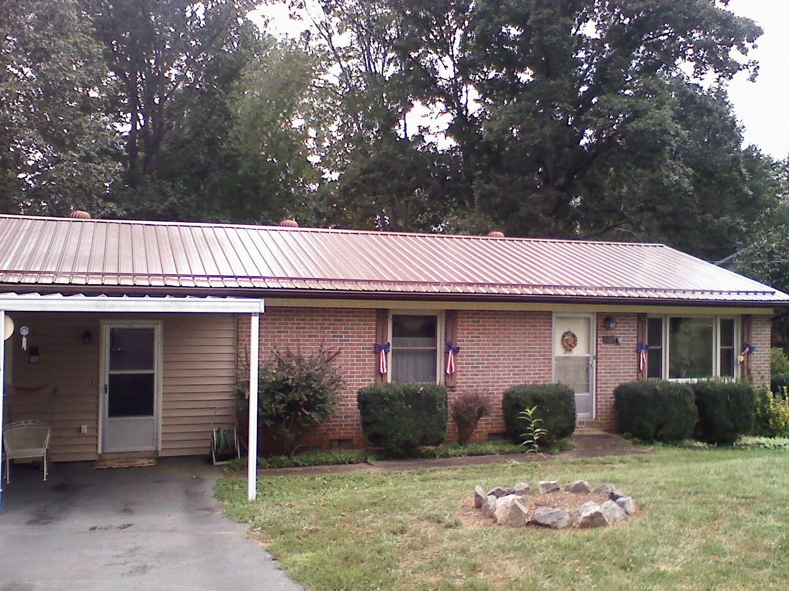 Bronze metal roof and carport on a brick ranch home — Roof Repair work by our crew in Harbor Springs